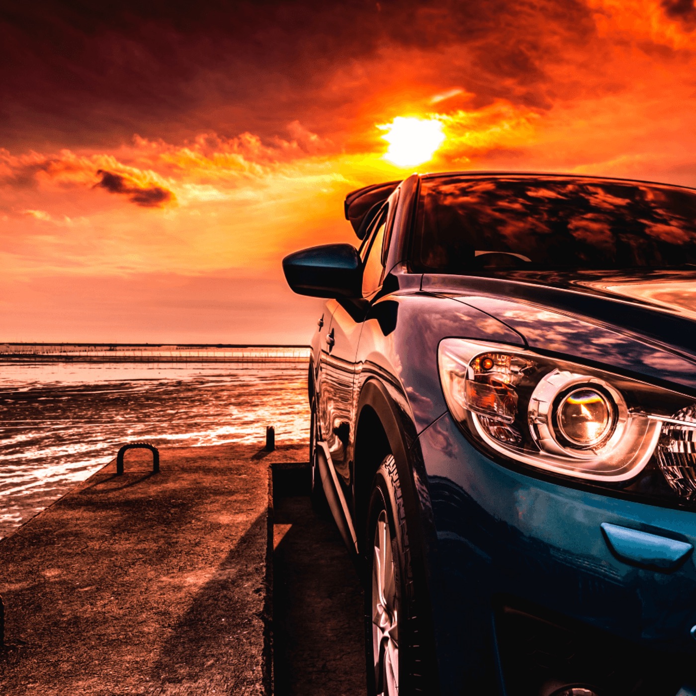 Voiture SUV garée face à la mer au coucher du soleil, à protéger avec le bon traceur GPS